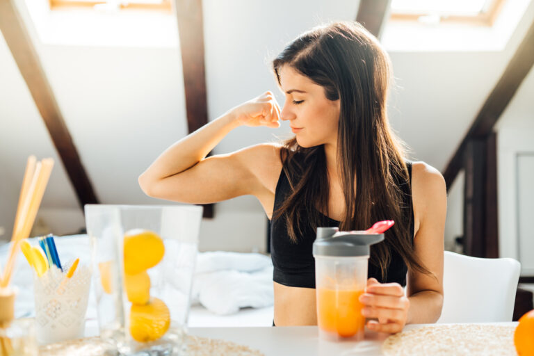 Woman,At,Home,Drinking,Orange,Flavored,Amino,Acid,Vitamin,Powder